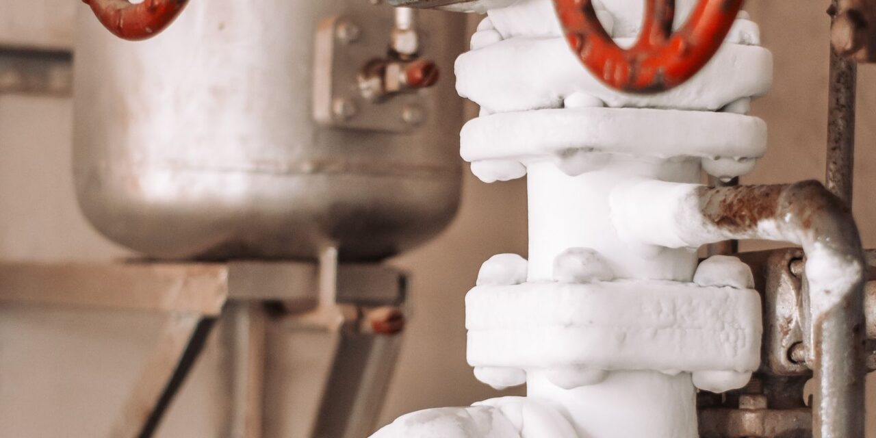 Red valve handle on insulated industrial steam piping